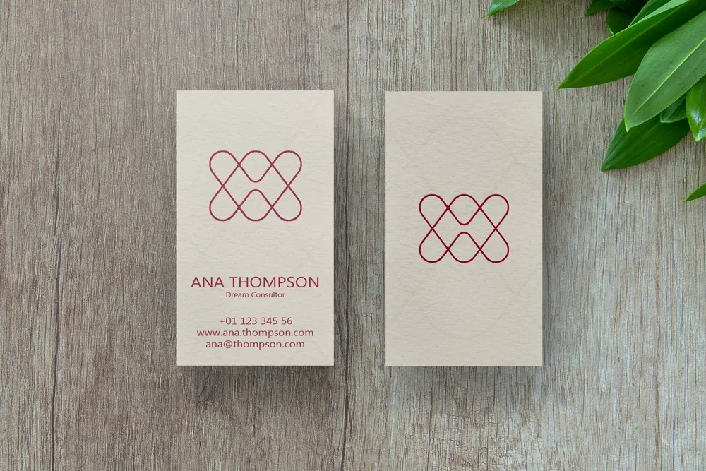 Some Modern Elegant business cards with red logo and clean professional design on wooden background.